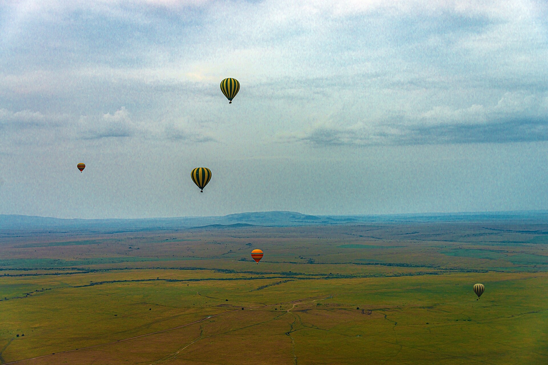 Hot air balloons drifting over the Serengeti at dawn